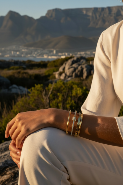 Close-up gold bangles on wrist in South African setting