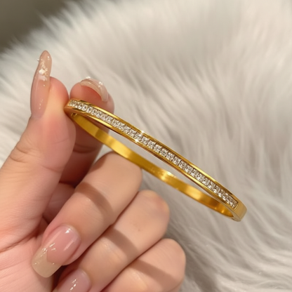 Hand holding gold zirconia bangle